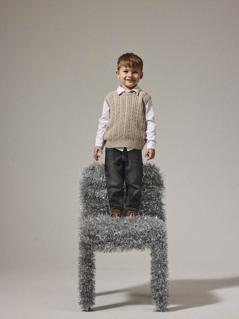Boy standing on a chair wearing Roman Knit Vest-Island Fossil