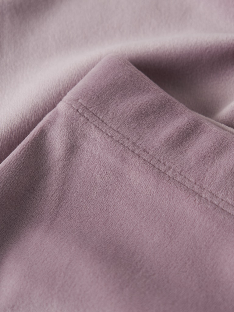 Close-up of a folded piece of mauve fabric with a visible seam.