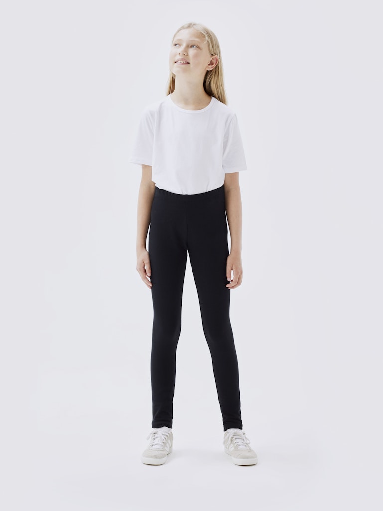 Person wearing a white t-shirt and black leggings on a white background