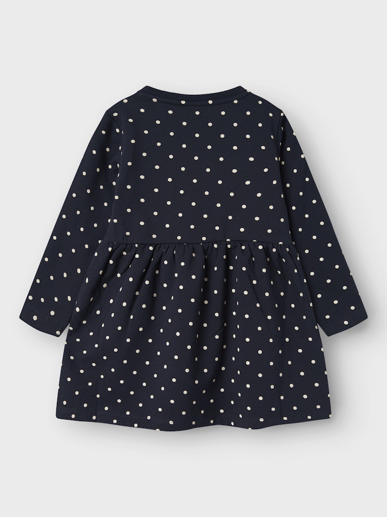 Navy blue dress with white polka dots on a light gray background