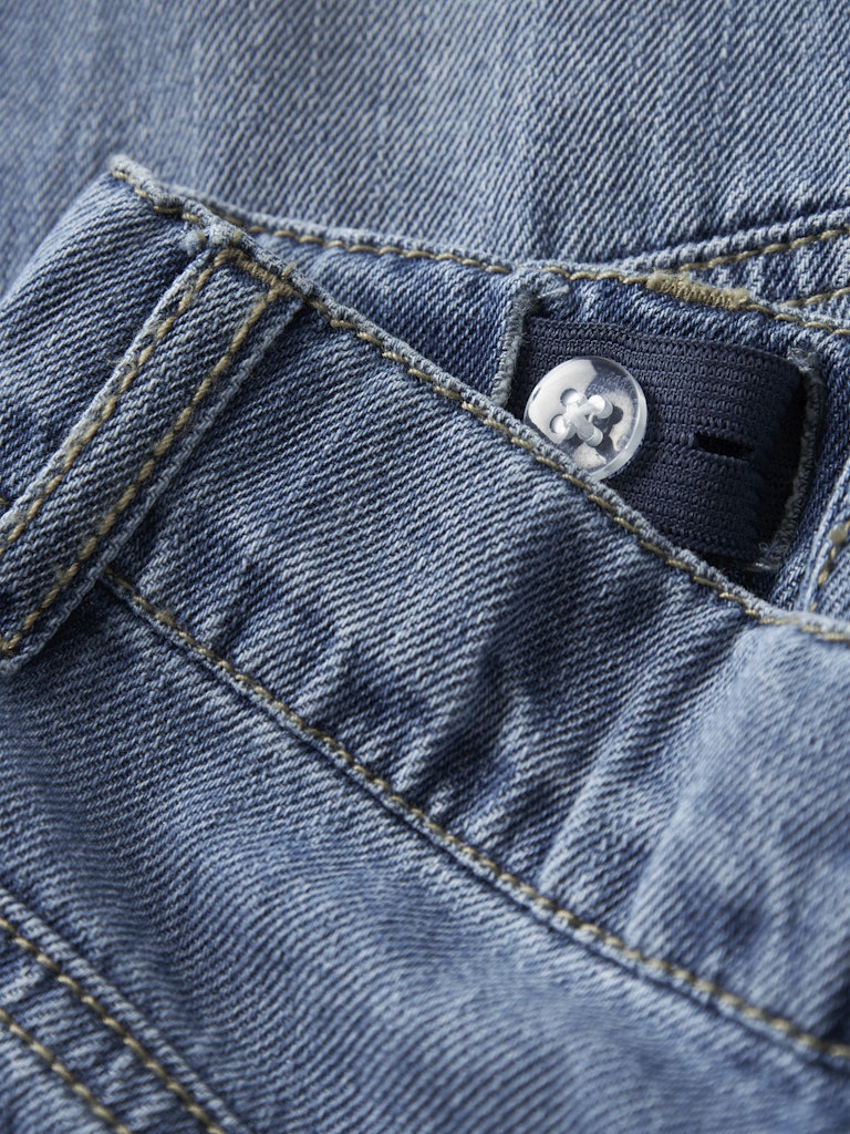 Close-up of a blue denim jacket with a button and stitching detail