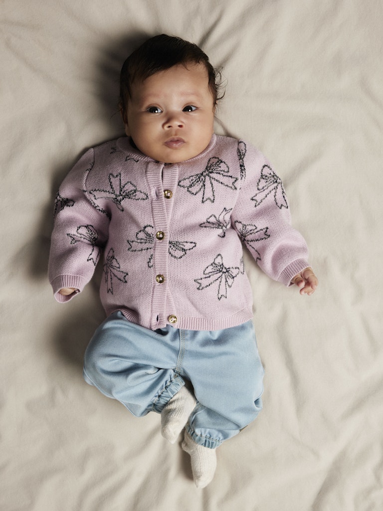 Baby wearing Rose Round Fit Light Blue Jeans with a pink cardigan