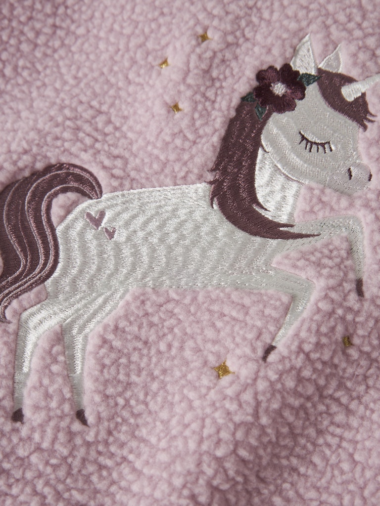 Embroidered unicorn design on a pink textured fabric background