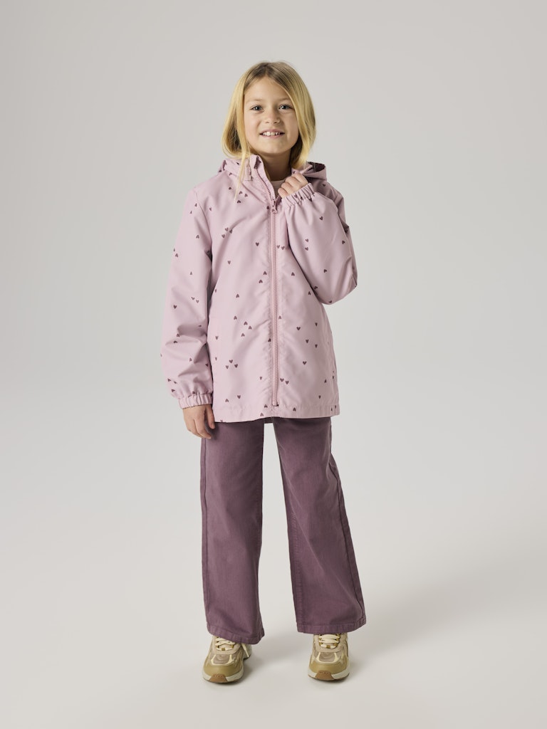 Child wearing a pink raincoat and matching pants on a white background