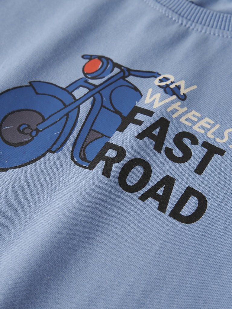 Light blue sweatshirt with a graphic of a motorcycle and text 'On Wheels Fast Road' on a plain background.