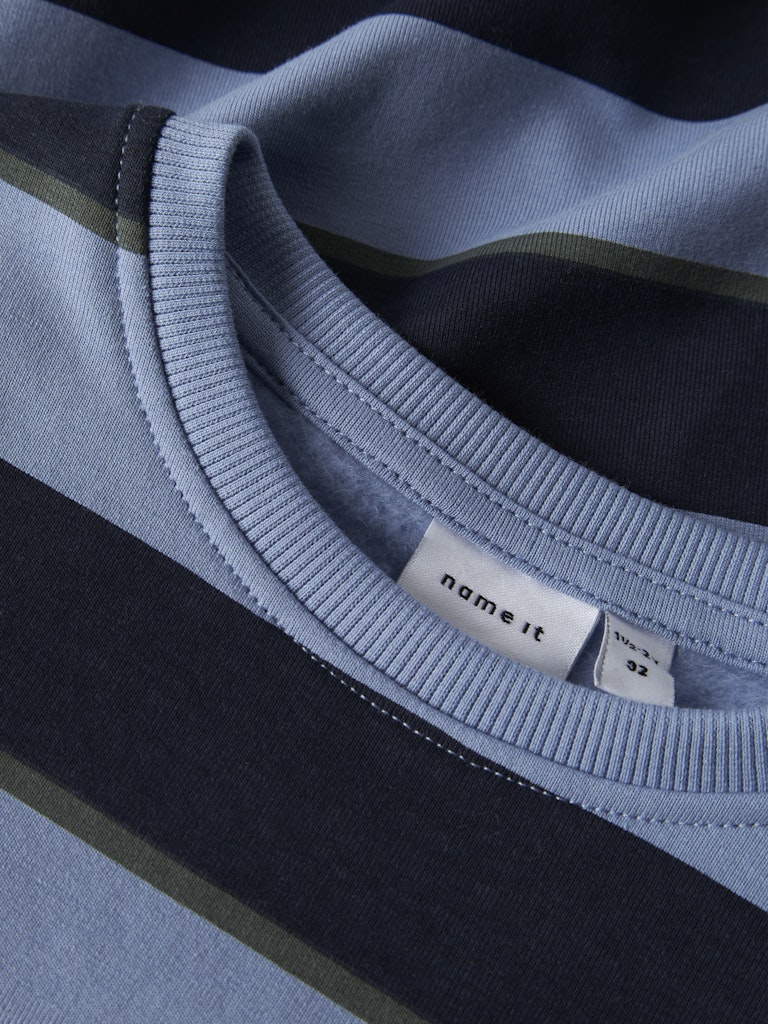 Close-up of a blue and black garment with 'name it' label