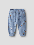Blue children's pants with vehicle print on a light gray background