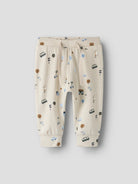 Beige children's pants with vehicle pattern on a light gray background
