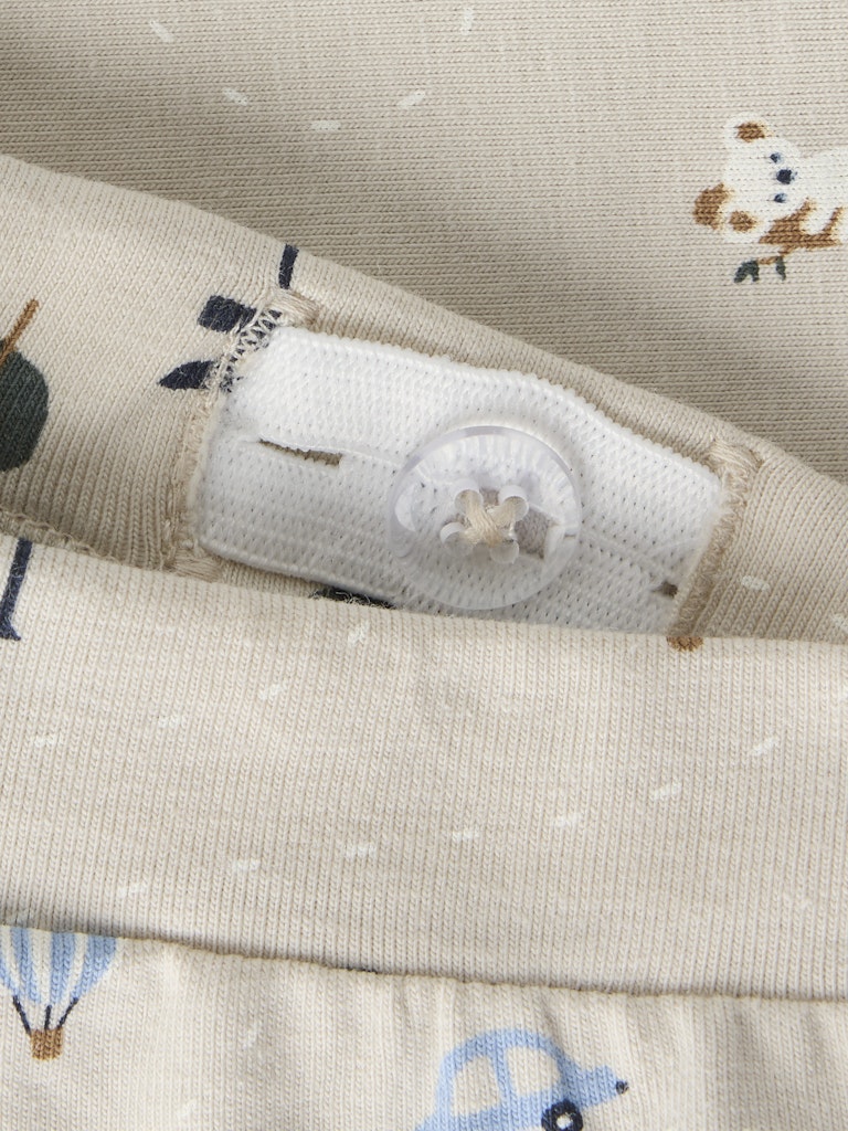 Close-up of a fabric with a button and cartoon character design on a beige background