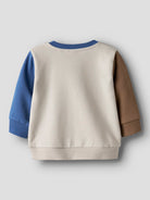 Color-blocked sweater with blue and brown sleeves on a light gray background