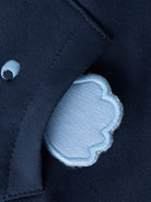 Close-up of a navy blue fabric with a light blue patch on a dark background