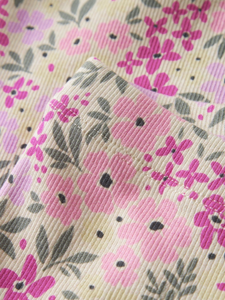 Close-up of floral fabric with pink and purple flowers on a beige background