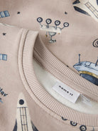 Close-up of a fabric with space-themed design and 'name it' label.