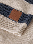 Close-up of a striped sweater with a brown leather patch and 'Rory & Shy' branding.