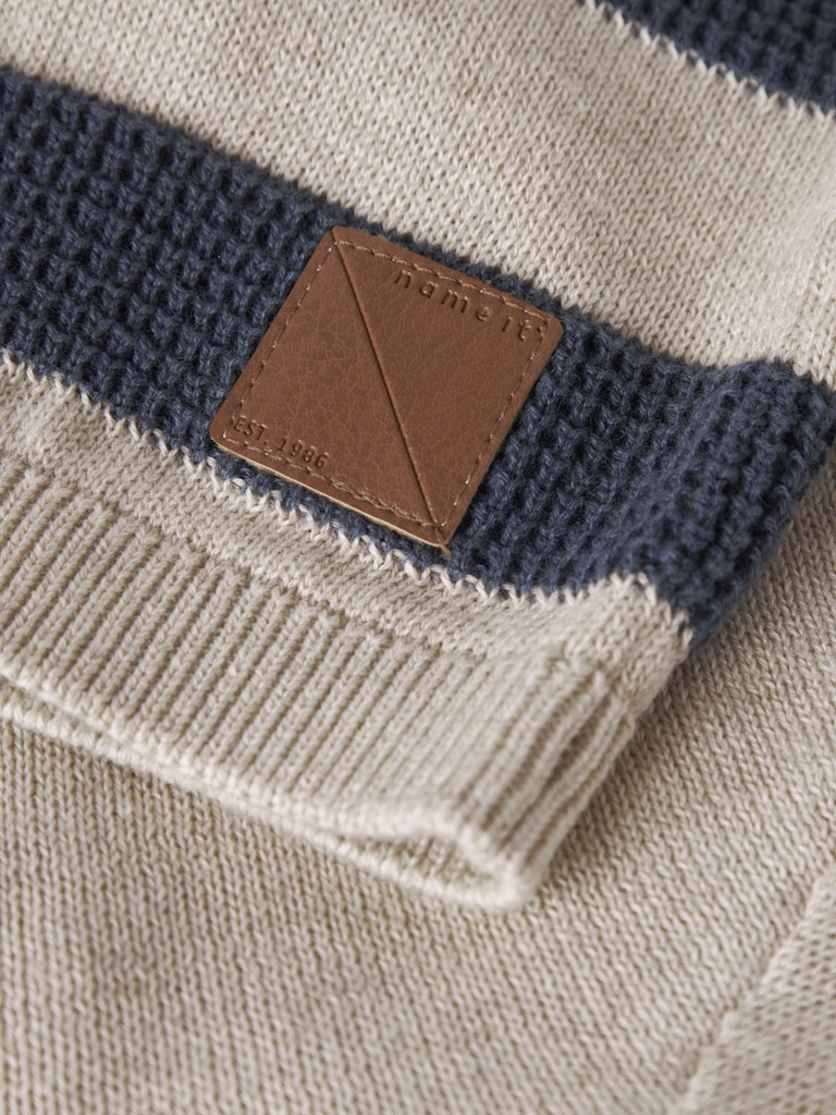 Close-up of a striped sweater with a brown leather patch and 'Rory & Shy' branding.
