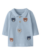 Light blue polo shirt with bear face designs on a white background