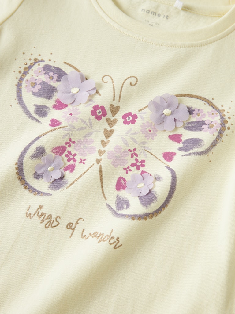 Children's shirt with a butterfly design and 'Wings of wonder' text on a light background