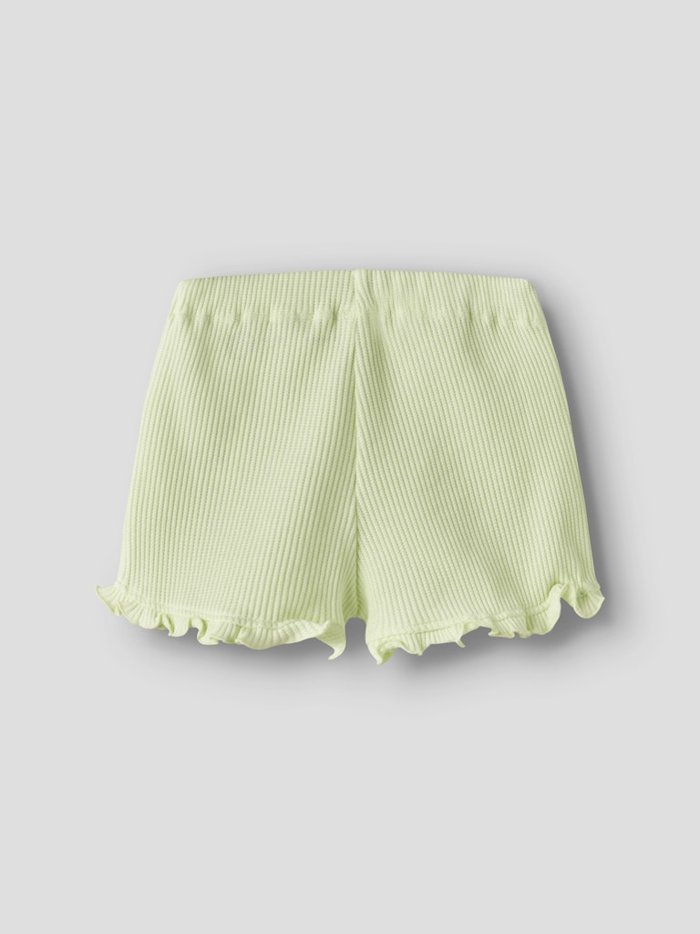 Light green shorts with ruffled hem on a gray background
