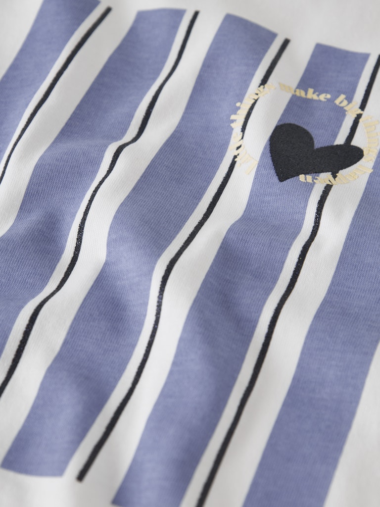 Close-up of a shirt with blue and white stripes and a black heart design.