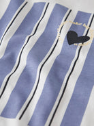 Close-up of a shirt with blue and white stripes and a black heart design.