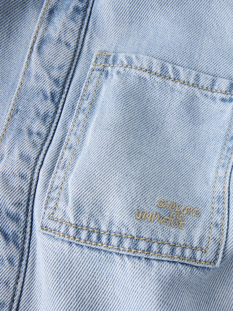 Close-up of a light blue denim jacket pocket with 'Uniqlo' branding.