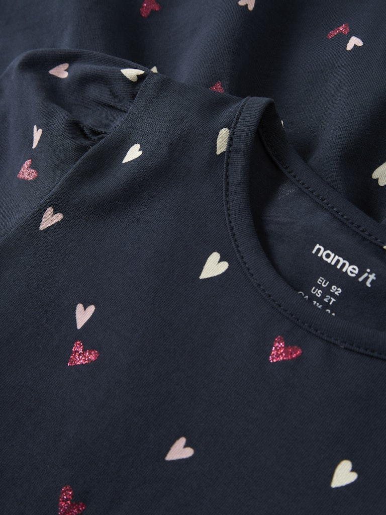Navy blue fabric with heart patterns and 'name it' brand label.