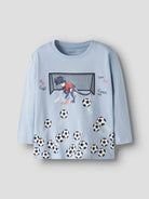 Light blue long sleeve top with dinosaur playing football graphic