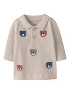 Beige polo shirt with embroidered bear faces on a white background