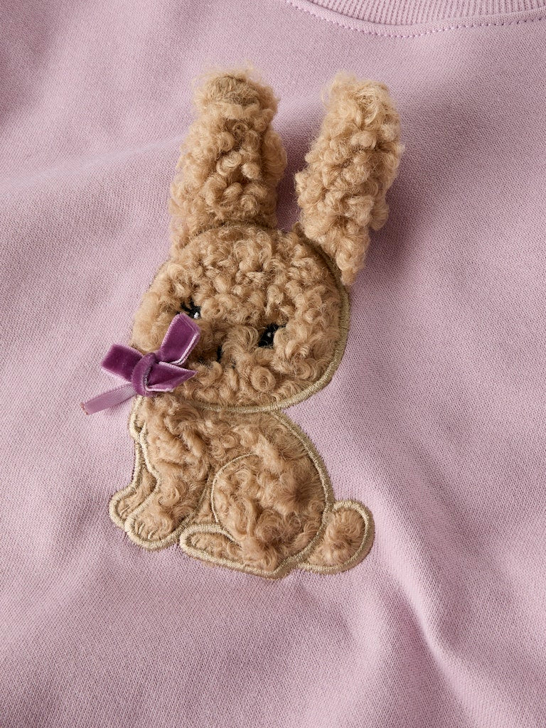 Beige bunny patch with a purple bow on a pink background
