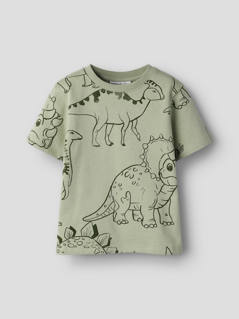 Green t-shirt with dinosaur prints on a white background