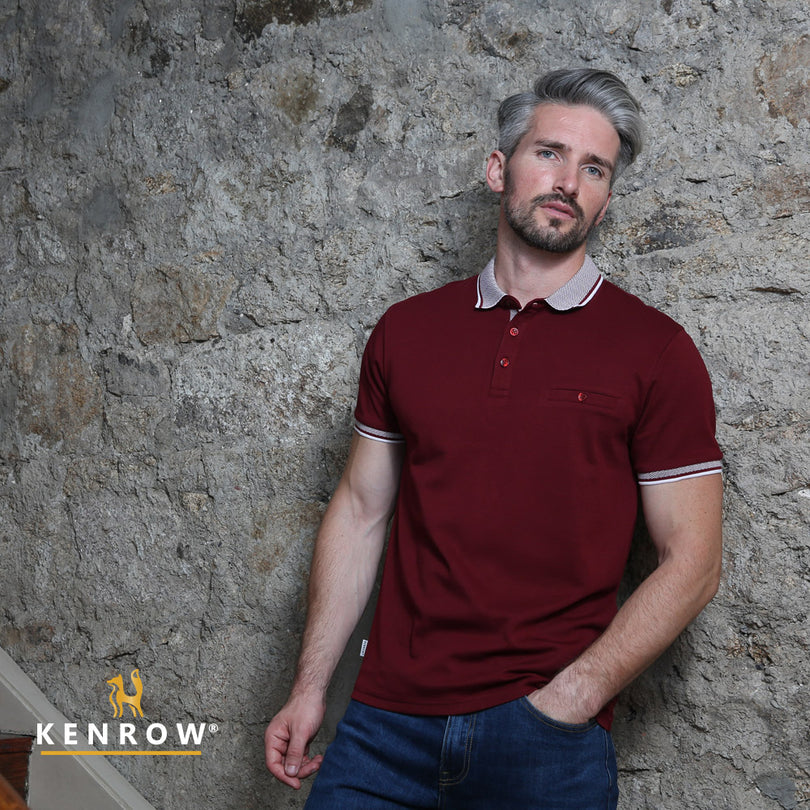 Man wearing a maroon polo shirt against a stone wall with 'Kenrow' branding.