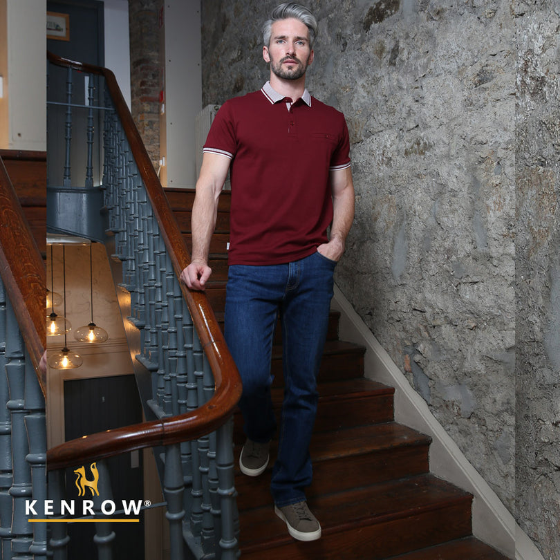 Man in a red polo shirt and blue jeans standing on a staircase with 'Kenrow' branding.