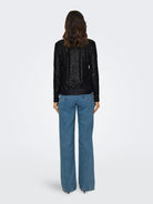 Back view of the black sequin long sleeve top on model