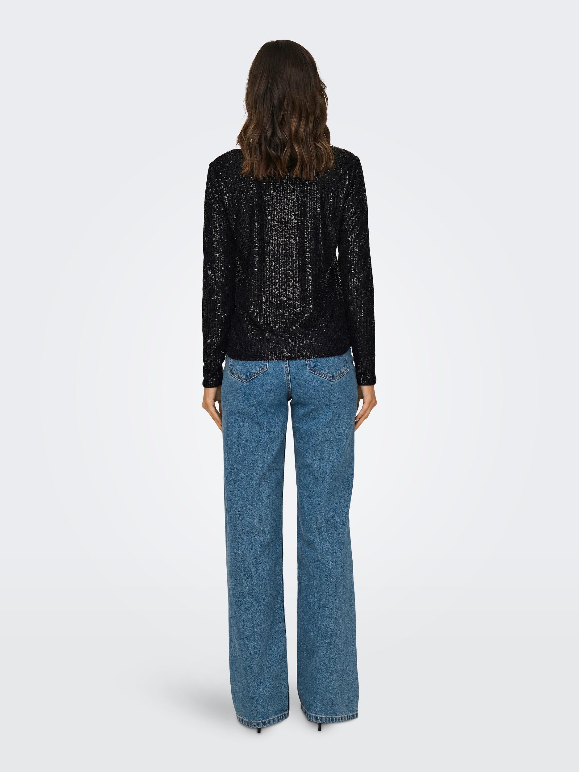 Back view of the black sequin long sleeve top on model