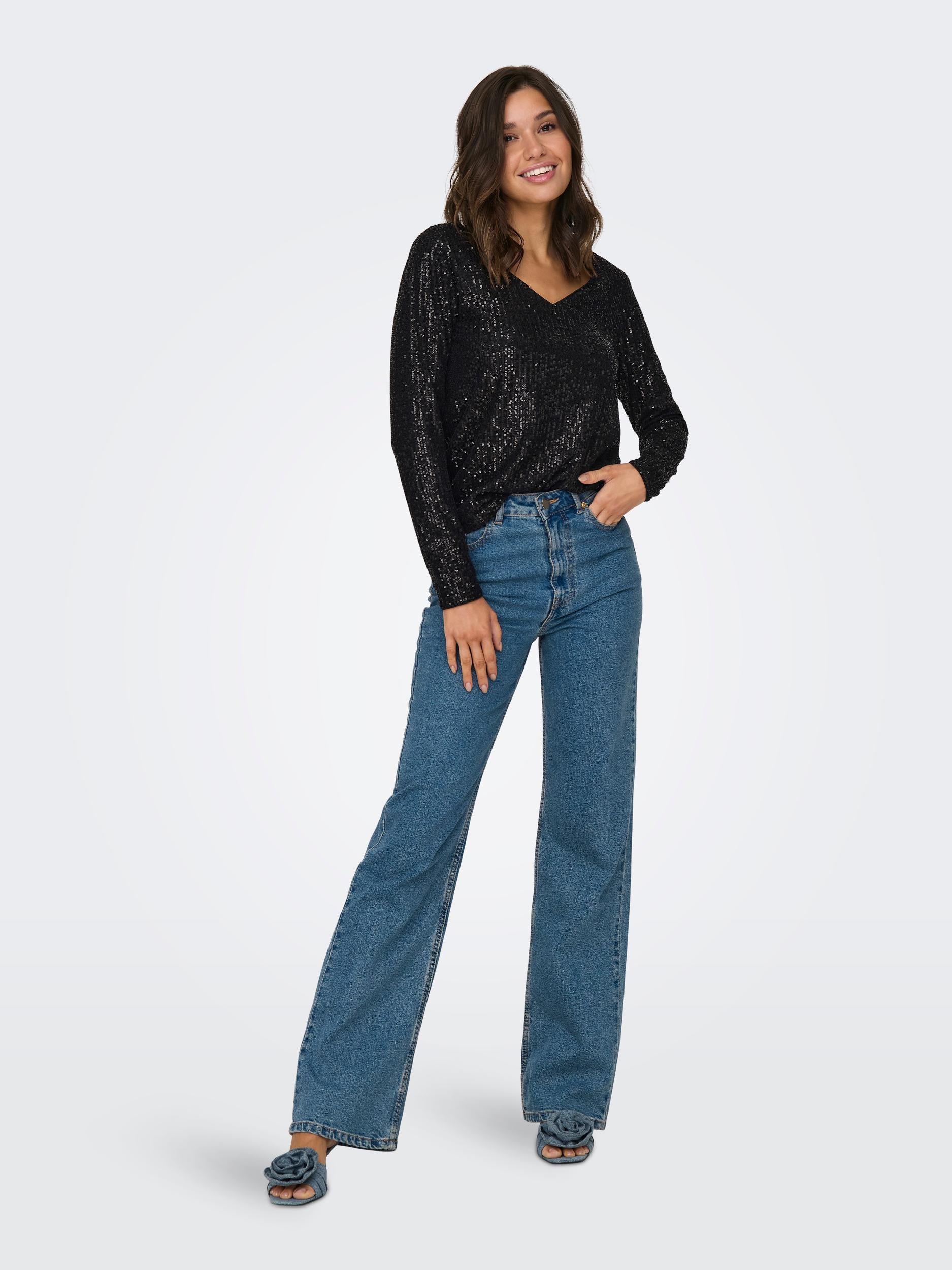 Full-length front view of the black sequin V-neck top on model