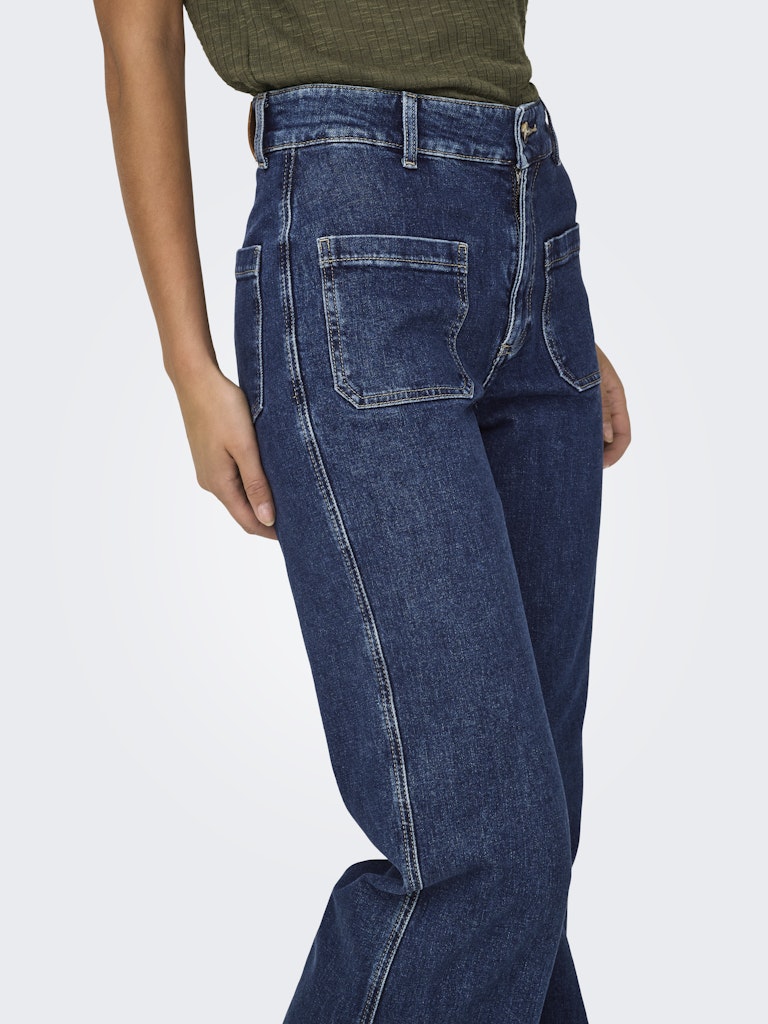 Blue jeans worn by a person on a white background