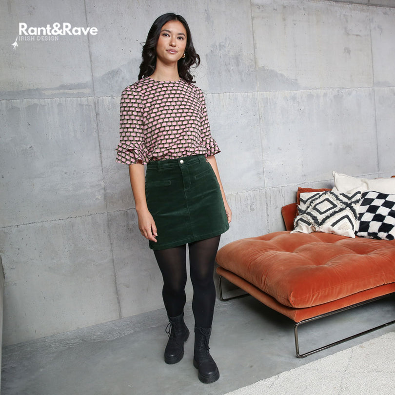 Woman standing in a modern interior setting with 'Rant&Rave' branding.