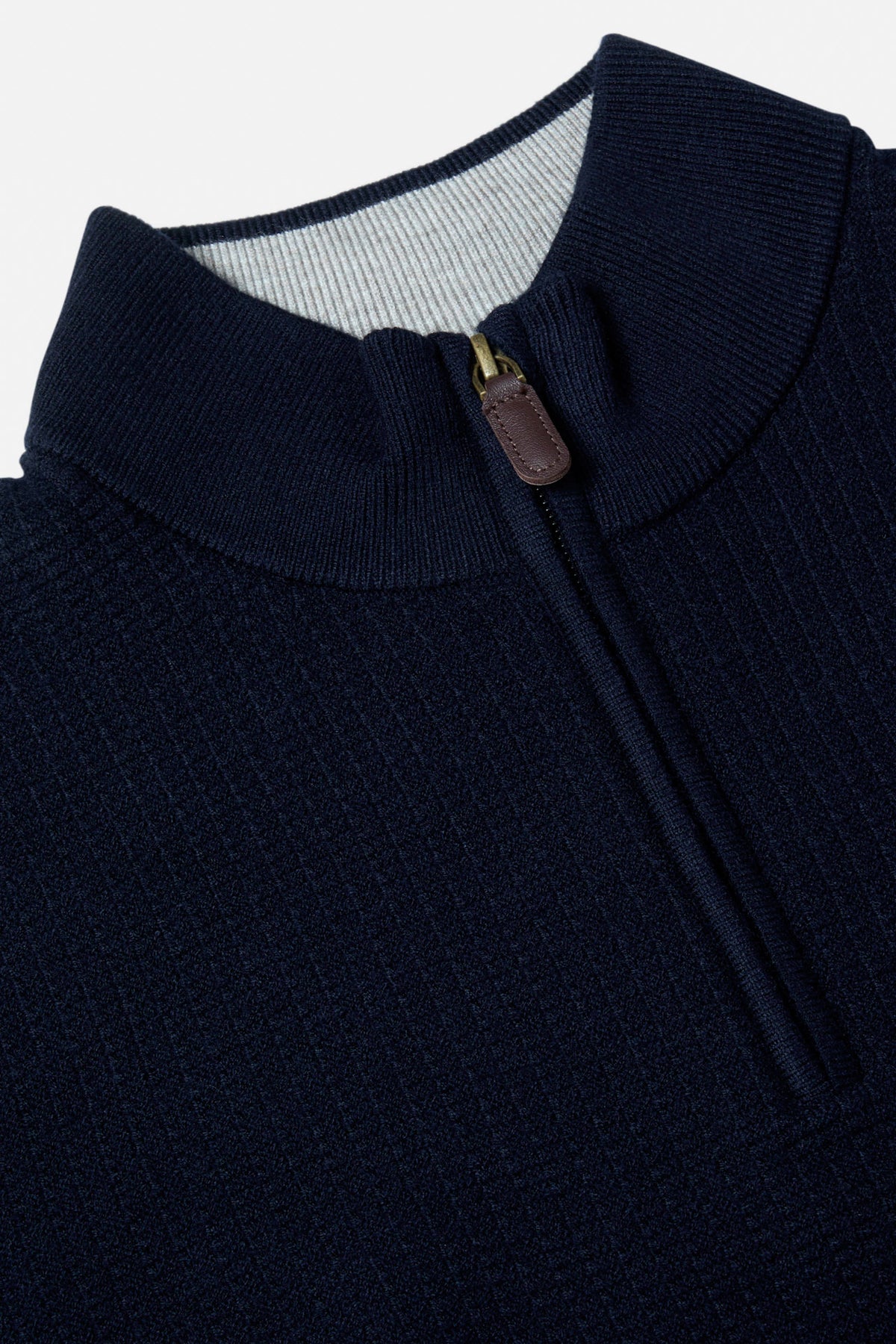 Close-up of the Benetti Oliver Navy 1/4 Zip knit collar and zip pull, with ribbed trim and textured navy fabric.