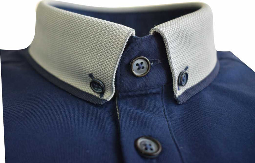 Close-up of a navy polo shirt with a contrasting knitted collar and buttons on a white background
