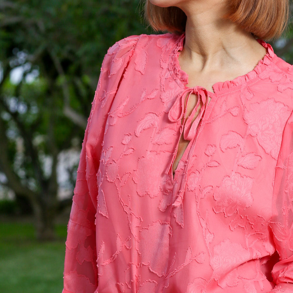 Detail view of the Primrose coral top fabric and neckline