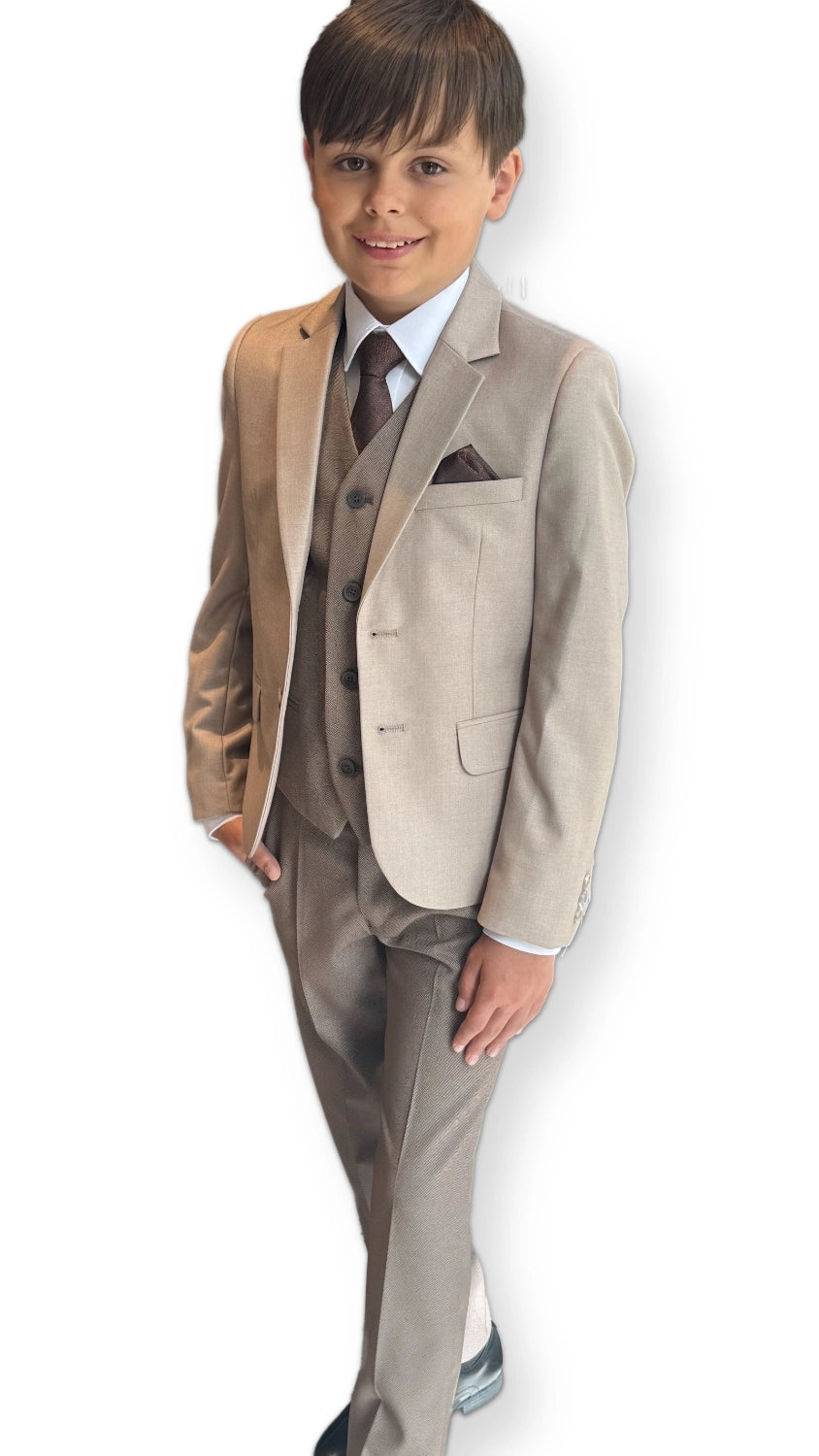 Young boy wearing a formal beige suit with a white shirt and brown tie on a white background