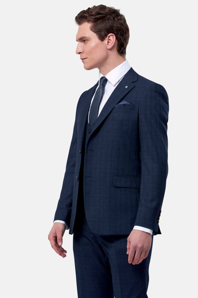 Man wearing a navy suit with a white shirt and tie on a light gray background