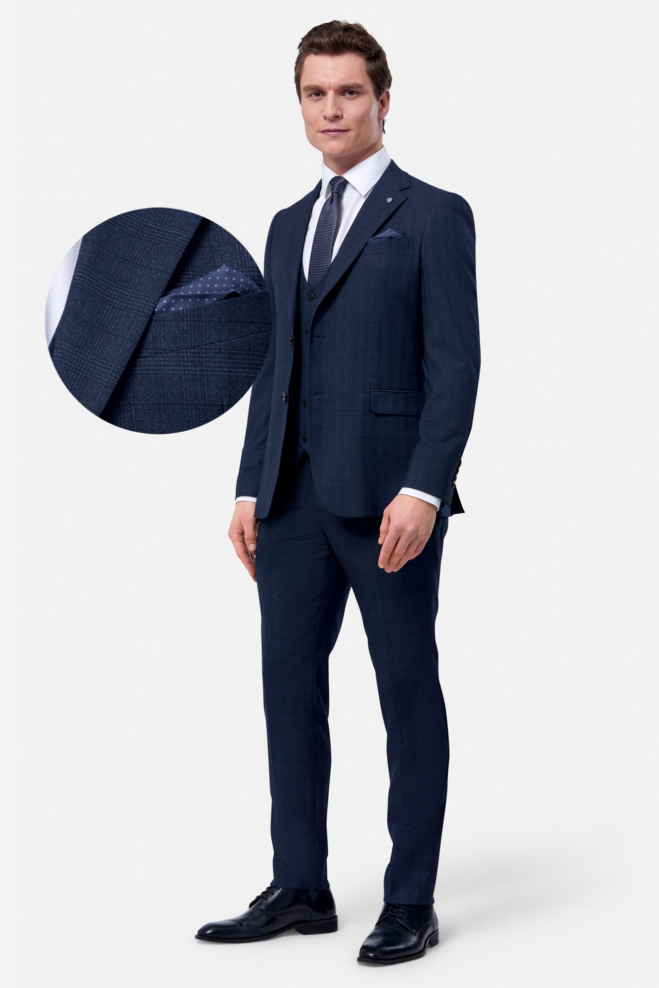 Man wearing a navy suit with a close-up of the jacket texture on a white background