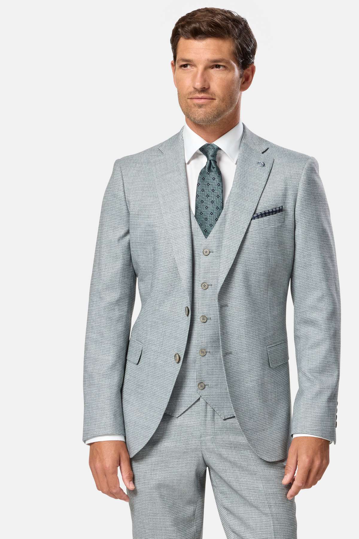 Man wearing a sage green checkered suit with a white shirt and patterned tie on a white background