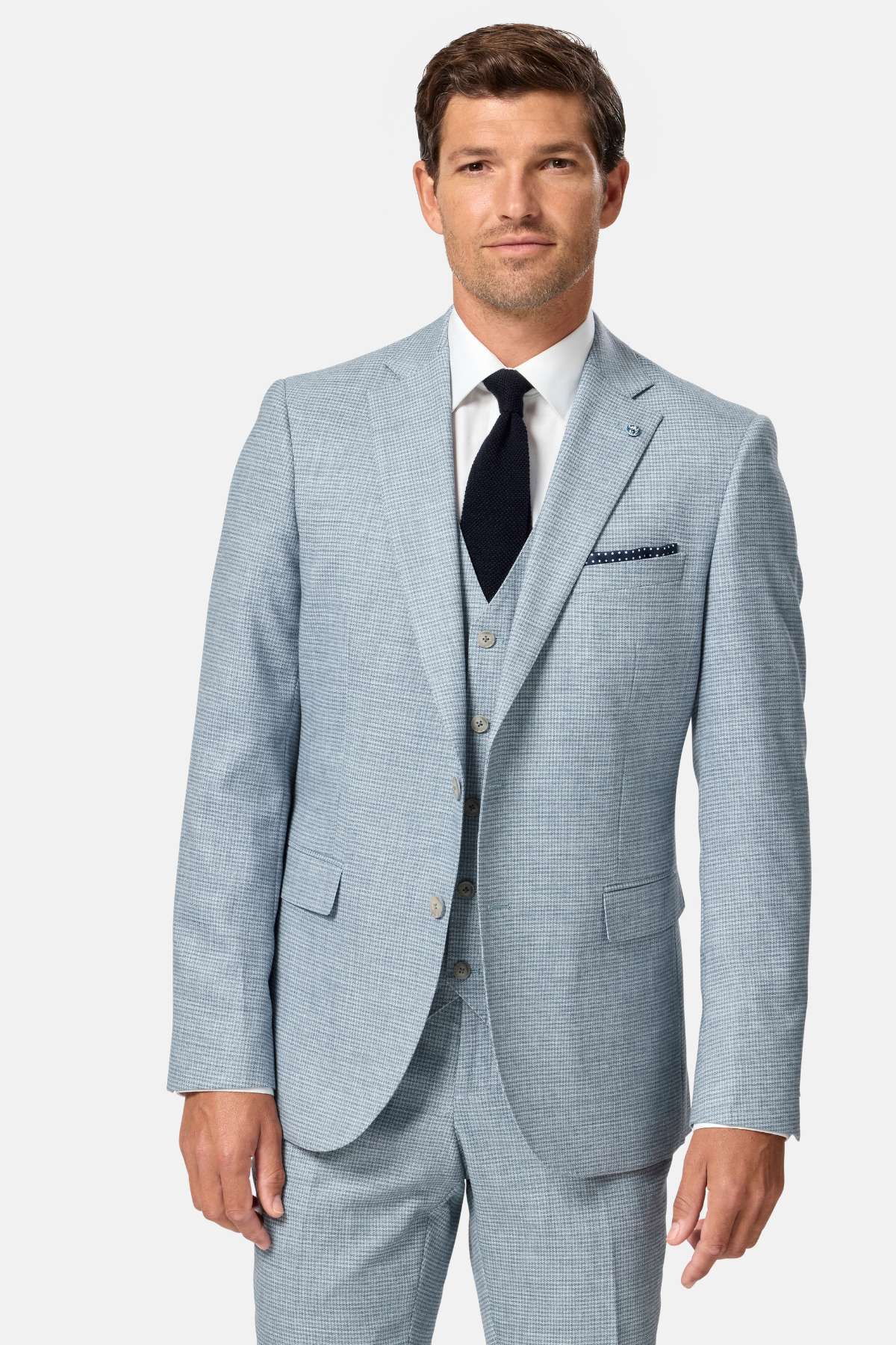 Man wearing a light blue checkered suit with a white shirt and black tie on a white background