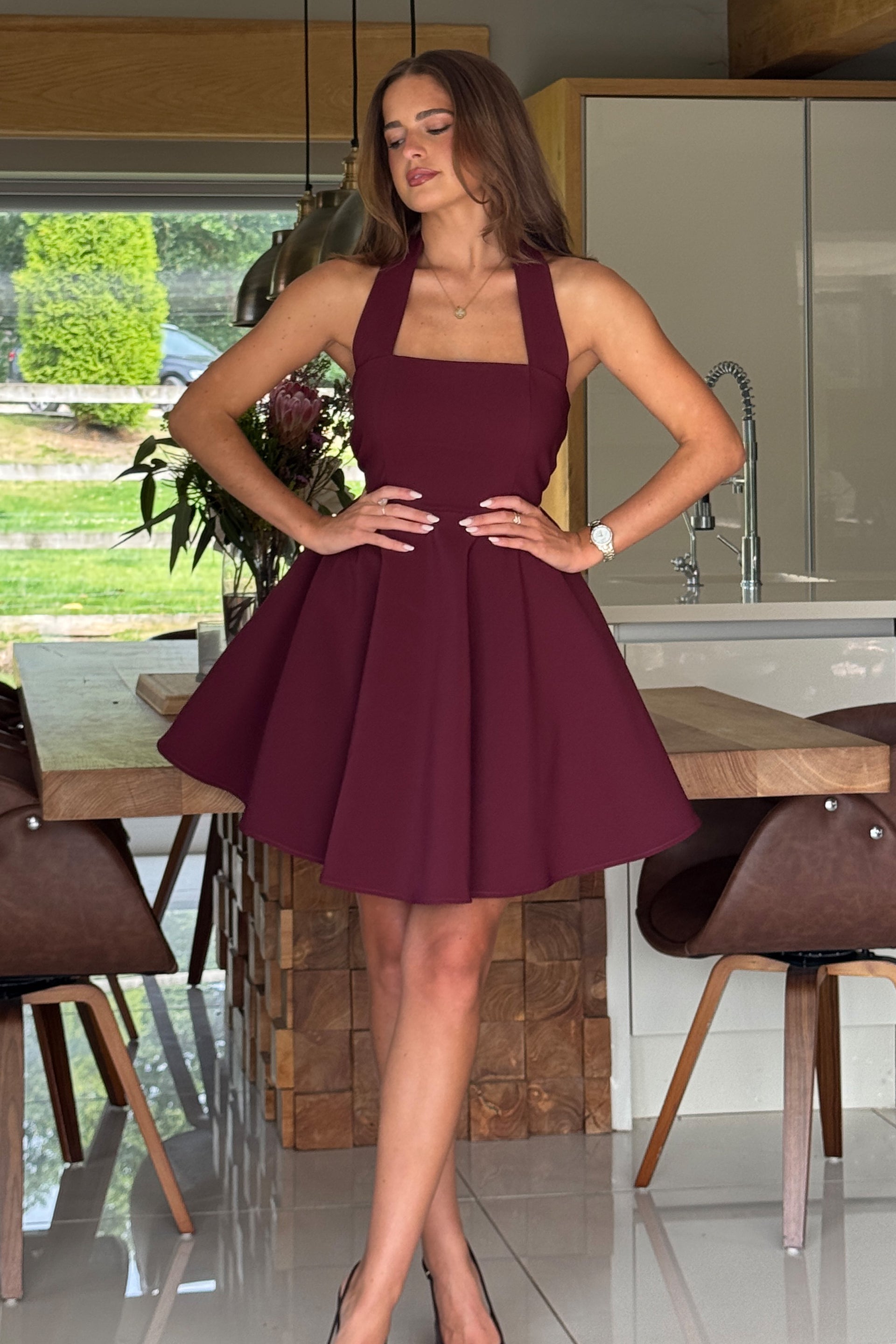 Woman wearing a burgundy dress in a modern kitchen setting