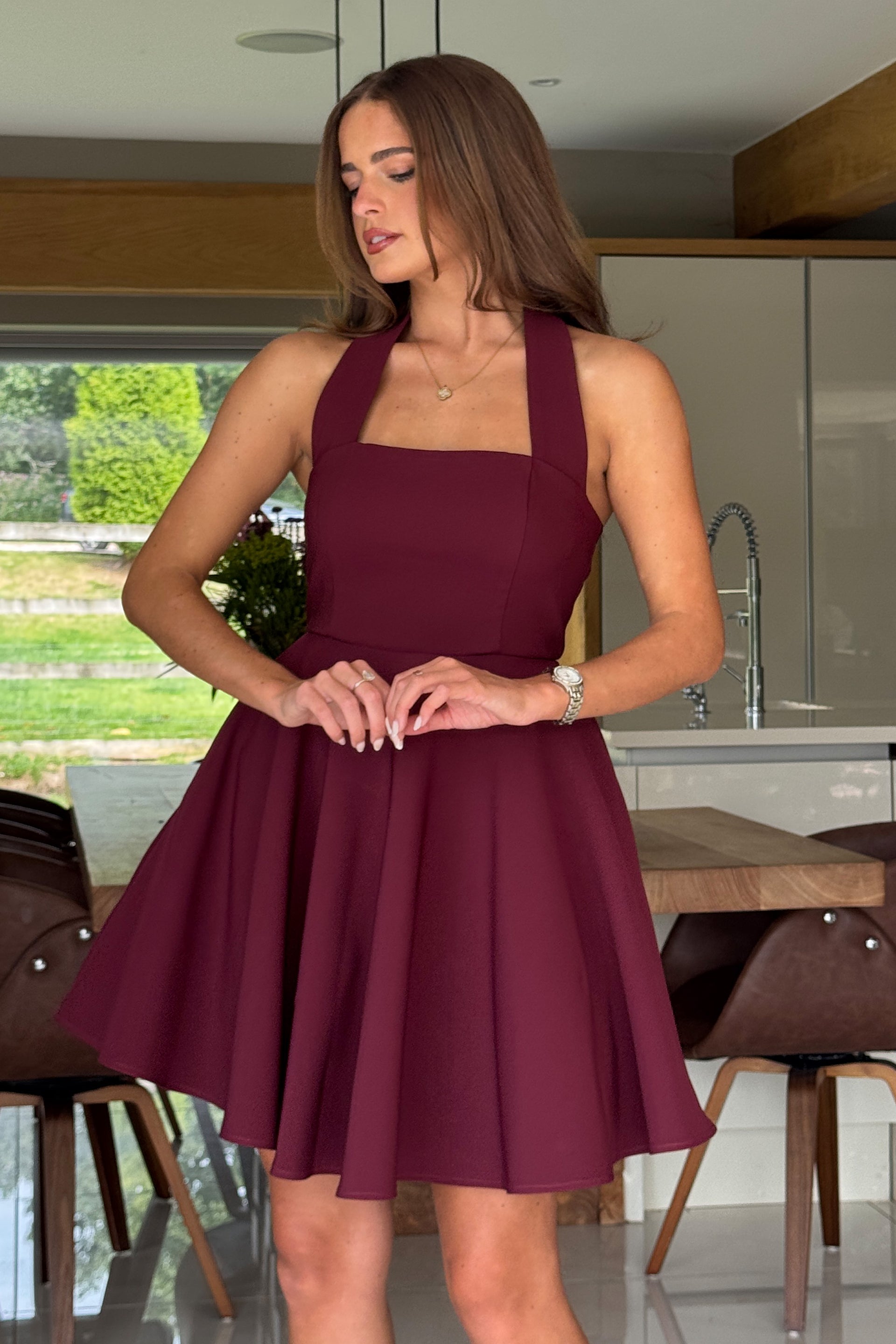 Woman wearing a burgundy dress in a kitchen setting