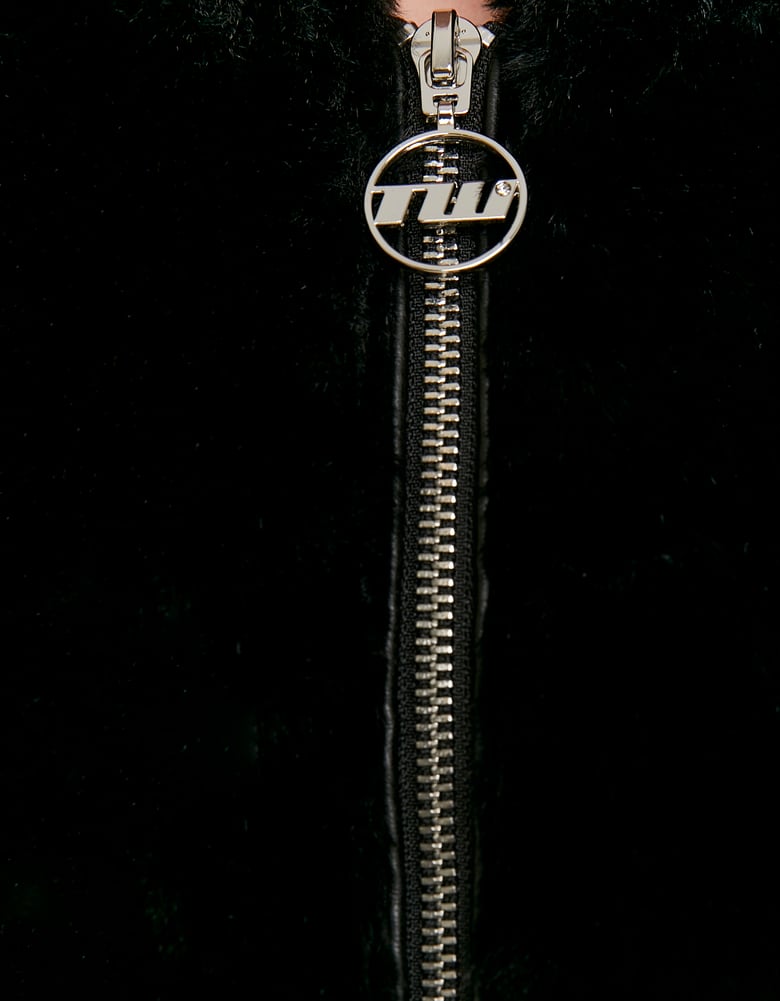Zip fastening detail on black fur jacket