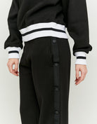 Detail view of the black wide leg joggers side button