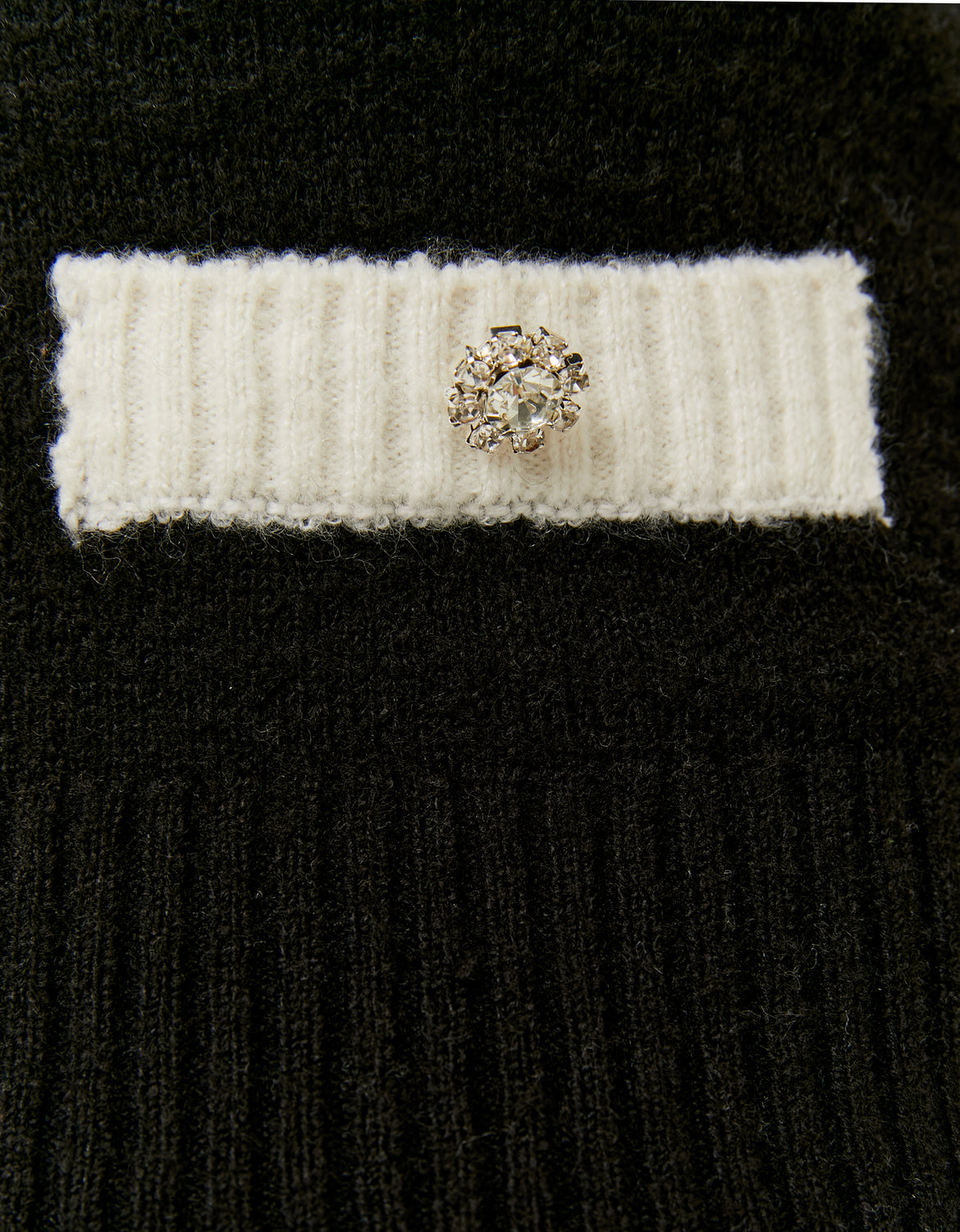 Close-up of contrast details on black cropped jumper